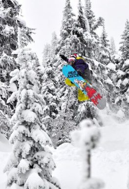 A snowboarder hitting a jump at Red Mountain Resort - Rams Head Inn